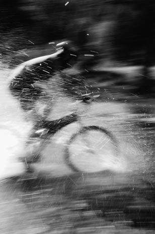Bicylist splashing through puddle